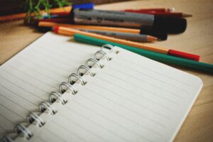 a notepad with a collection of pens and pencils